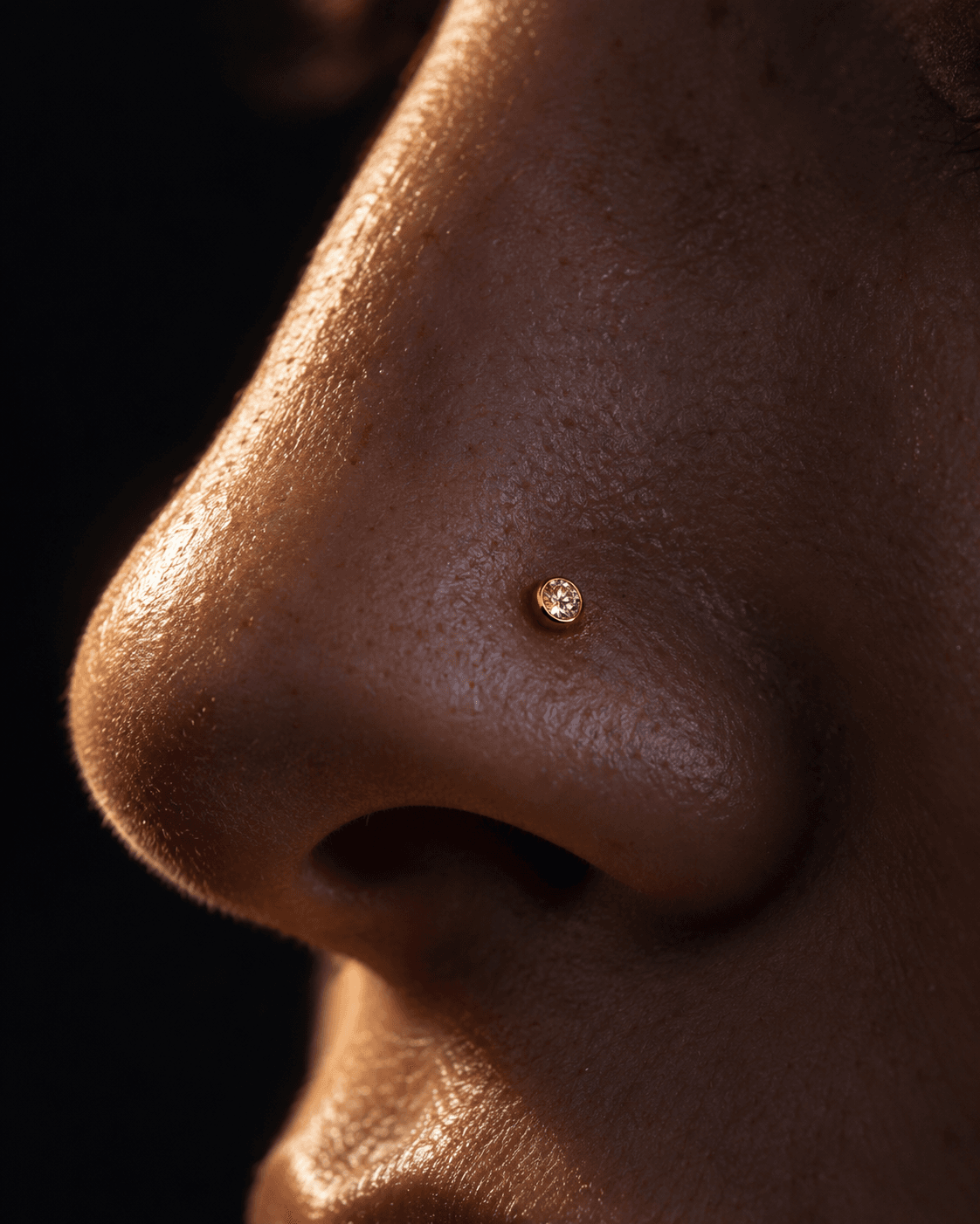 Close de nostril com pedra pequena em ouro.
