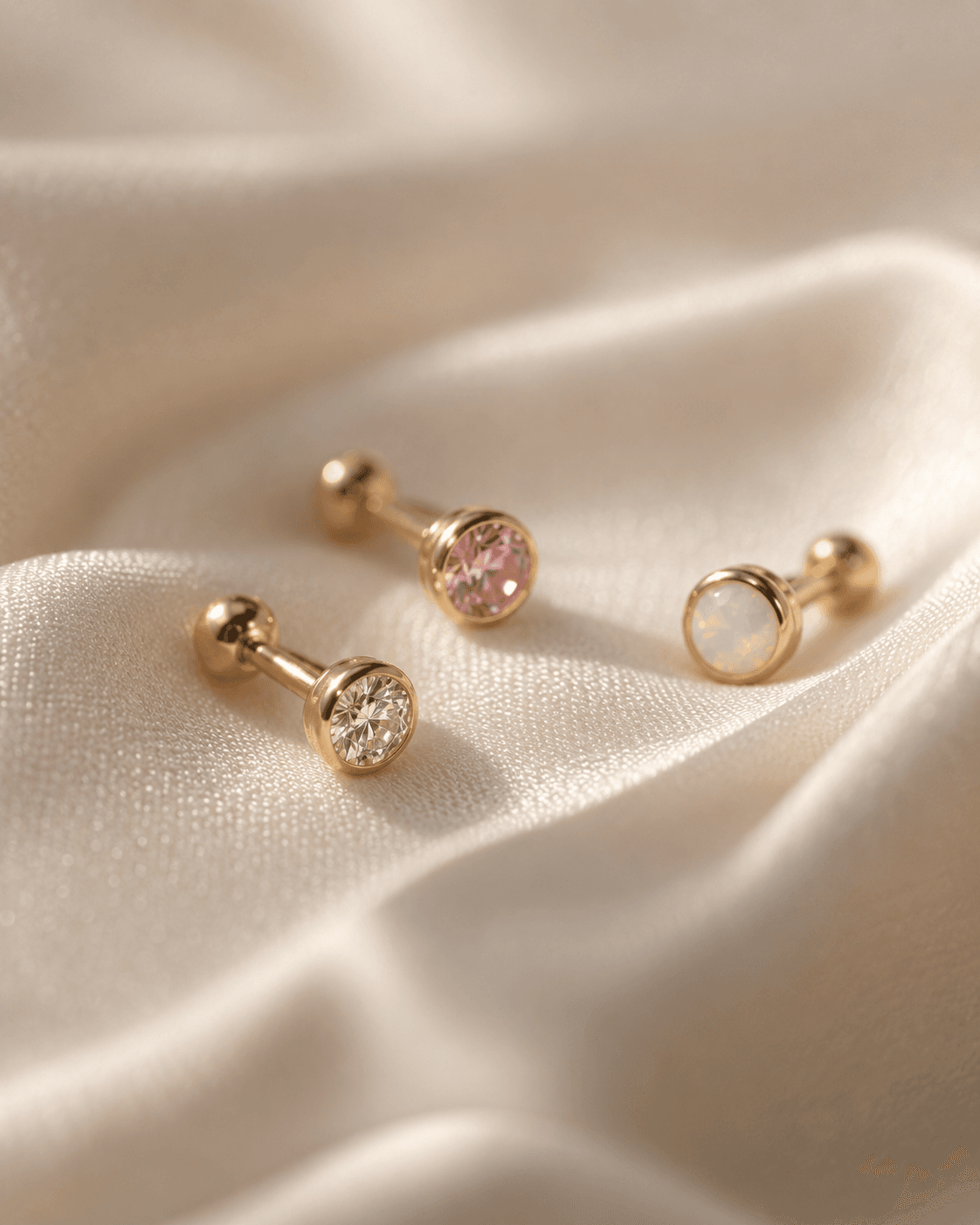 Studs de ouro com pedras preciosas pequenas em macro extremo.