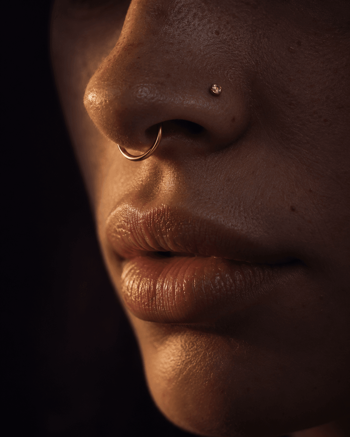 Retrato em close com piercing de septo e nostril em ouro.